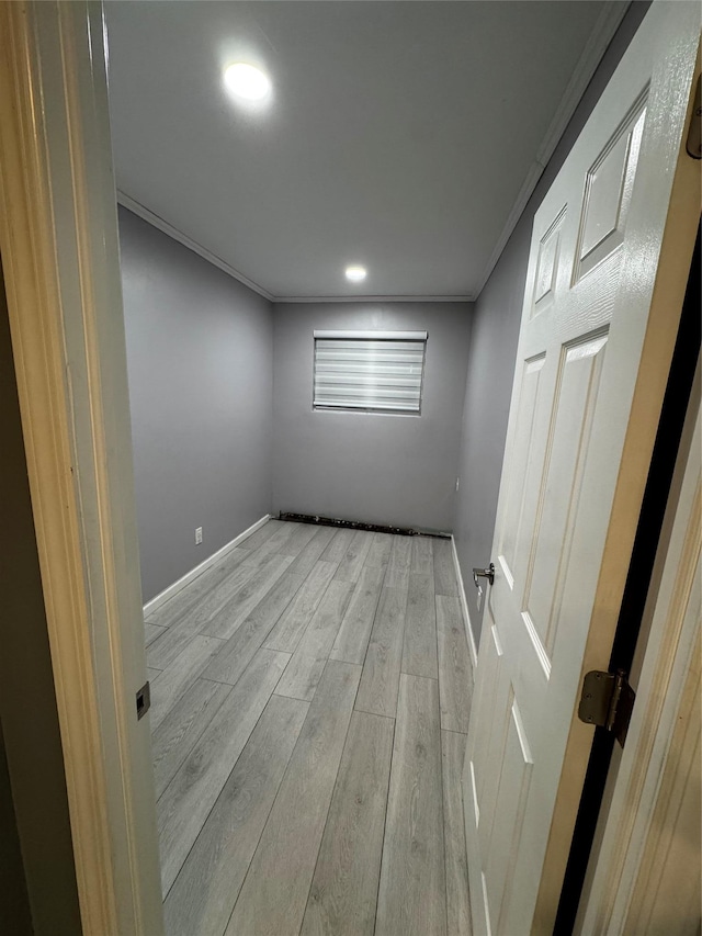 spare room with ornamental molding and light hardwood / wood-style floors