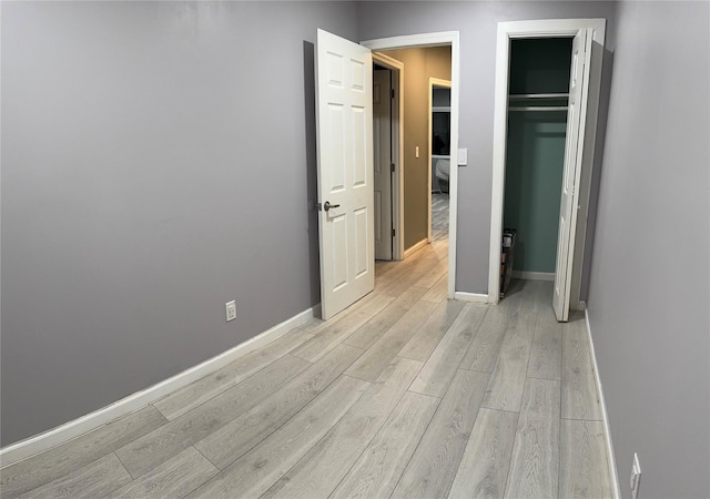 unfurnished bedroom with a closet and light hardwood / wood-style flooring