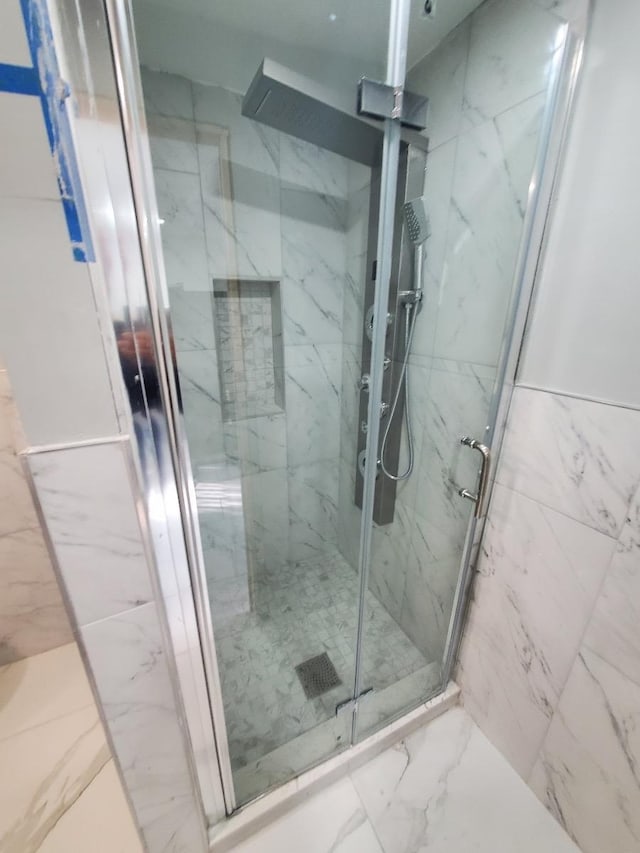 bathroom with a shower with door