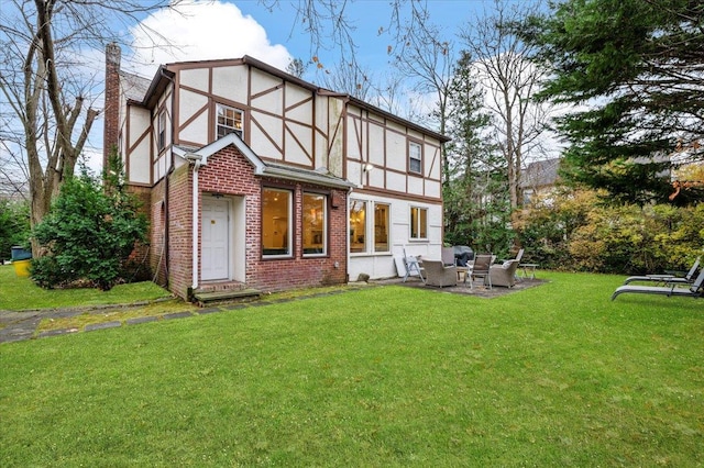 rear view of property featuring a yard and a patio area