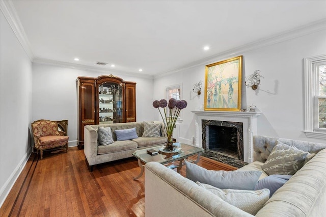 living room featuring ornamental molding, plenty of natural light, dark hardwood / wood-style floors, and a fireplace