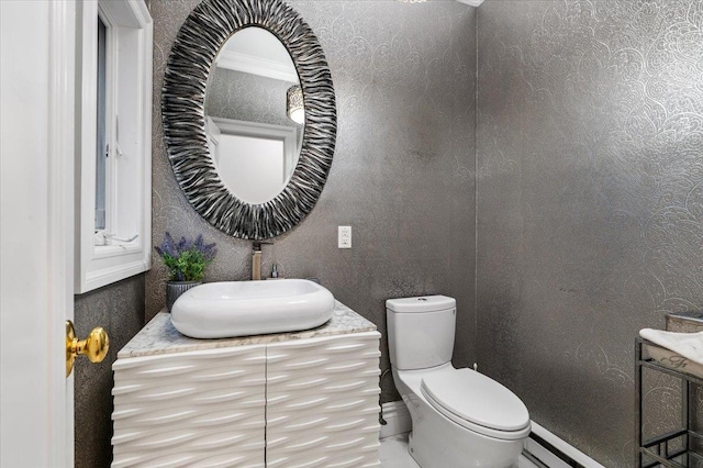 bathroom featuring crown molding, vanity, baseboard heating, and toilet