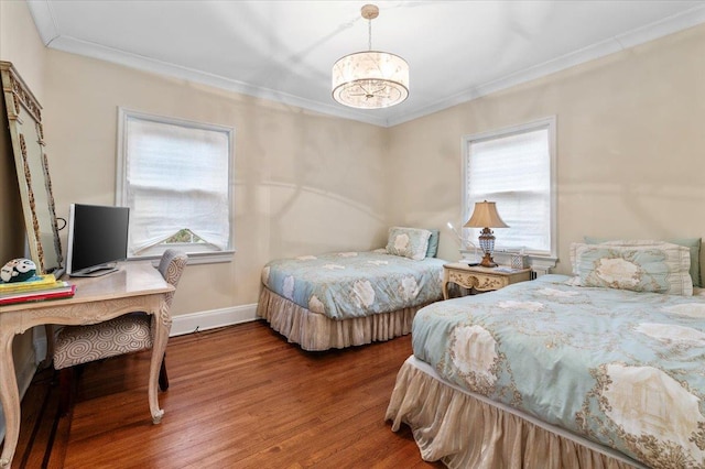 bedroom with ornamental molding, hardwood / wood-style floors, and an inviting chandelier