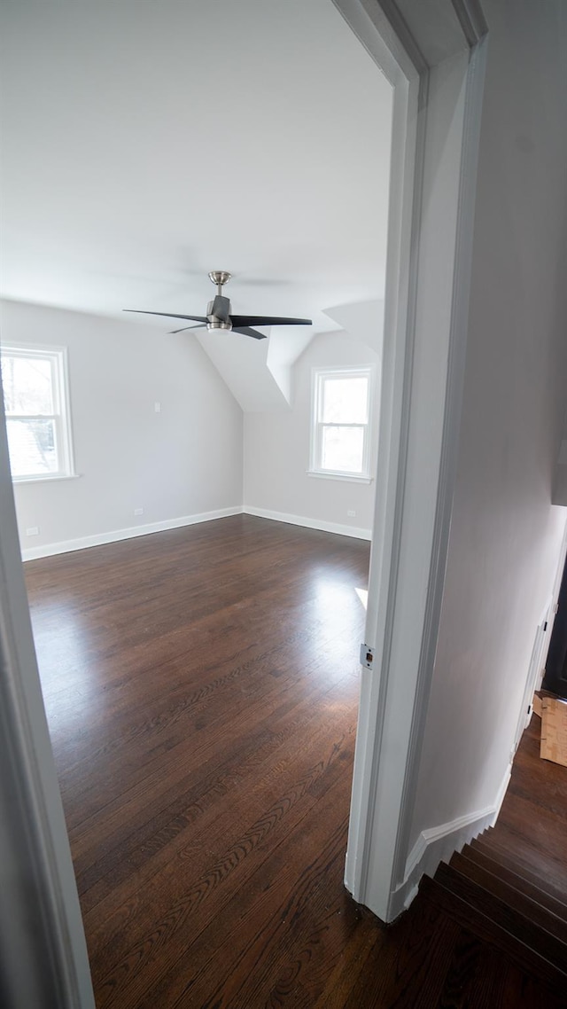 additional living space featuring dark wood-type flooring, ceiling fan, and vaulted ceiling