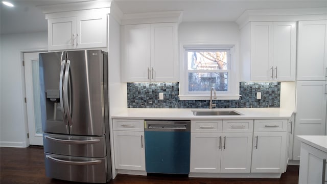 kitchen with appliances with stainless steel finishes, sink, white cabinets, dark hardwood / wood-style flooring, and backsplash