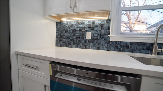 interior details with dishwasher, sink, decorative backsplash, and white cabinets