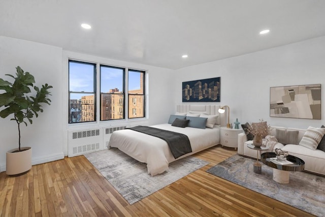 bedroom featuring radiator heating unit, light wood-type flooring, and recessed lighting