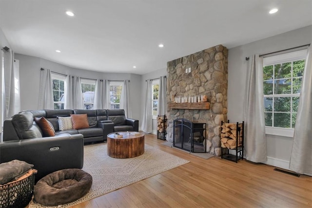 living room featuring a fireplace, plenty of natural light, and light hardwood / wood-style floors