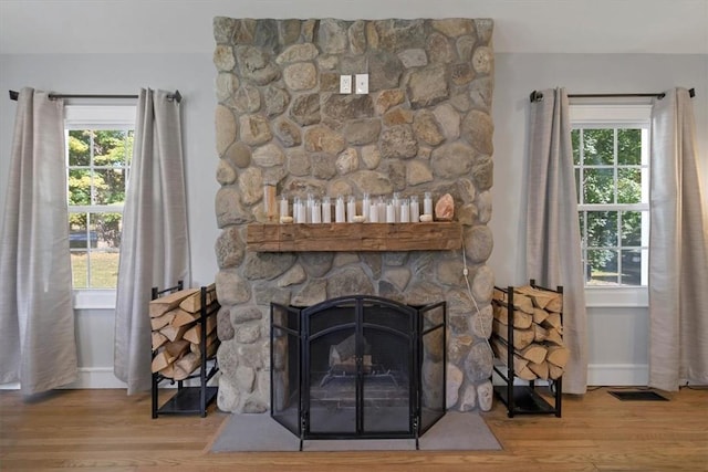 interior space with hardwood / wood-style flooring and a stone fireplace