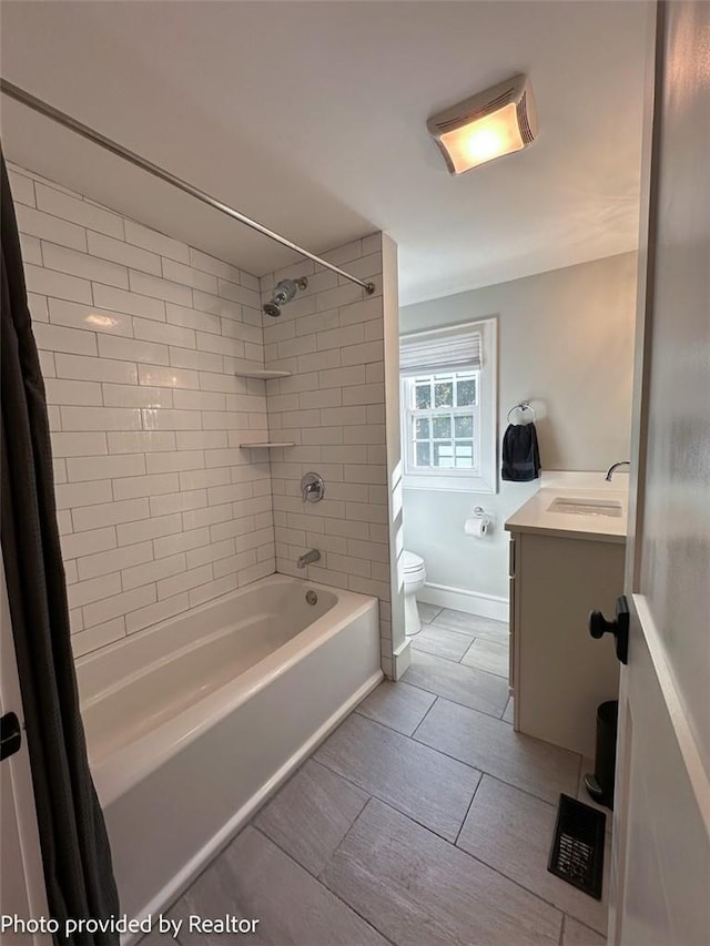 full bathroom with vanity, tiled shower / bath, and toilet