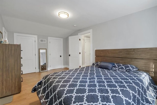 bedroom with wood-type flooring and lofted ceiling