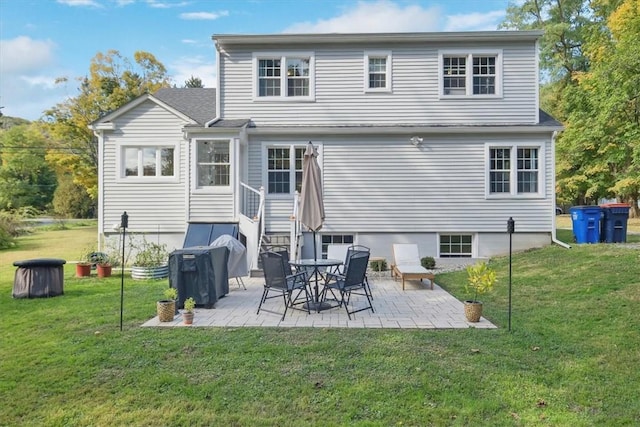 rear view of house featuring a lawn and a patio area