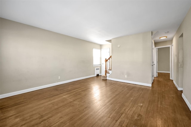 unfurnished room featuring radiator and dark hardwood / wood-style floors