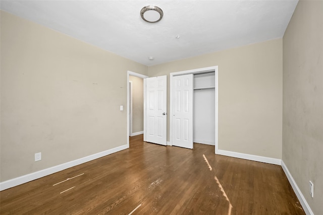 unfurnished bedroom with dark hardwood / wood-style floors and a closet