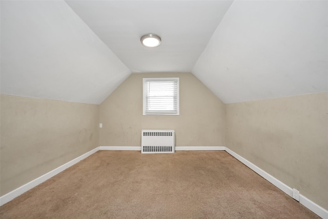 additional living space featuring lofted ceiling, carpet, and radiator heating unit