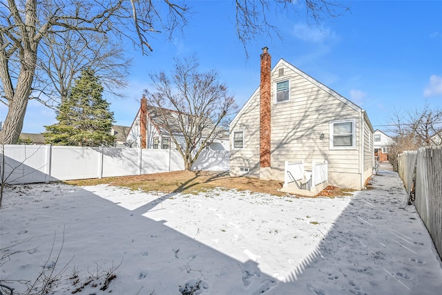 view of snow covered back of property