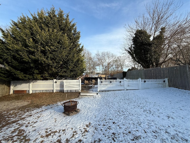 yard covered in snow with an outdoor fire pit