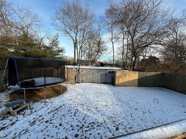 yard covered in snow with a trampoline