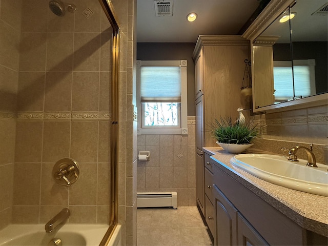 bathroom featuring tiled shower / bath, tile walls, a baseboard radiator, vanity, and tile patterned flooring