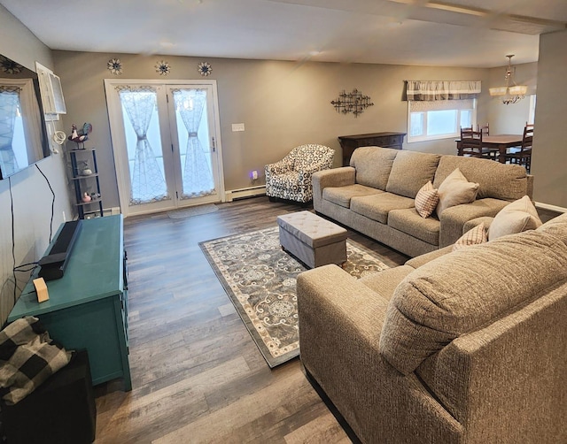 living room with a baseboard heating unit, an inviting chandelier, and dark hardwood / wood-style floors