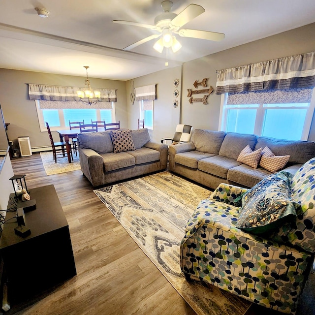 living room with hardwood / wood-style flooring and ceiling fan with notable chandelier