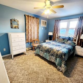 bedroom featuring an AC wall unit and ceiling fan