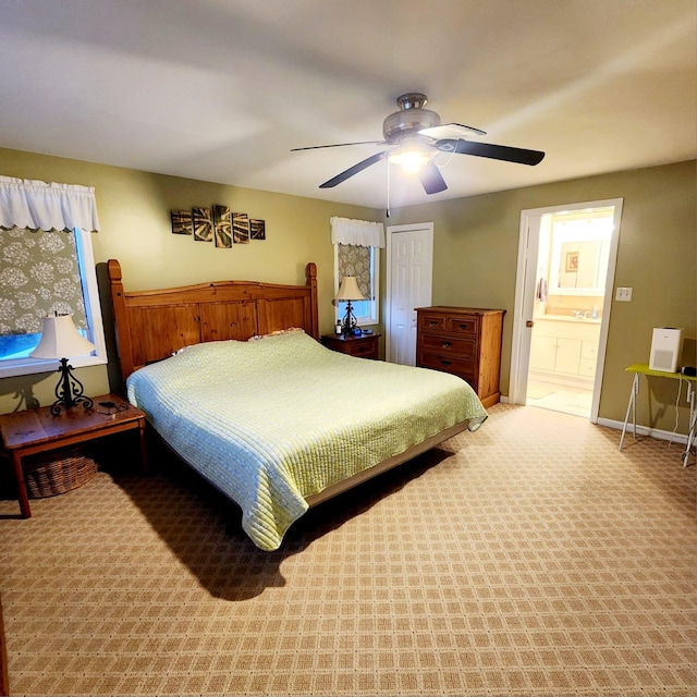 carpeted bedroom with ceiling fan and ensuite bathroom