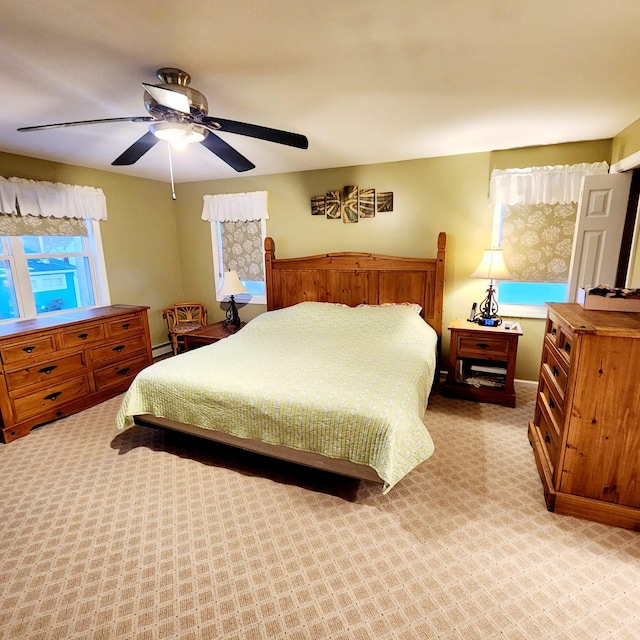 bedroom featuring light colored carpet, ceiling fan, and baseboard heating