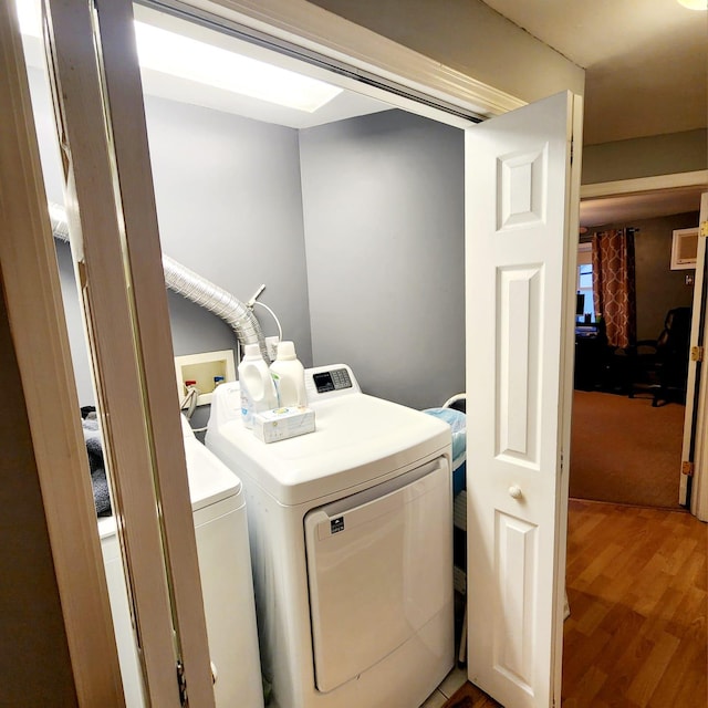 clothes washing area featuring hardwood / wood-style flooring and separate washer and dryer