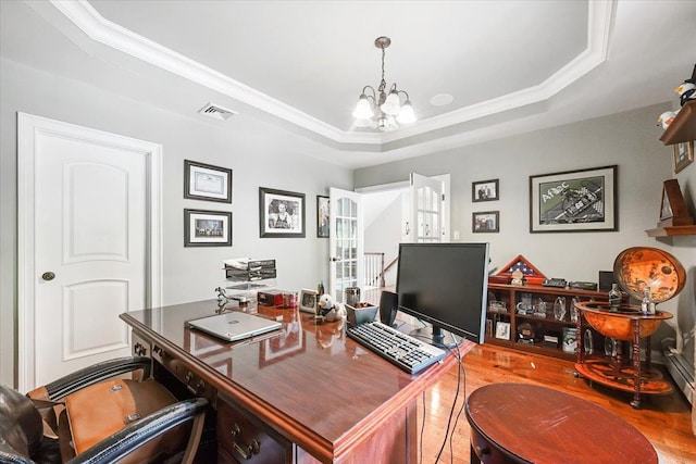 office area with an inviting chandelier, a tray ceiling, and crown molding