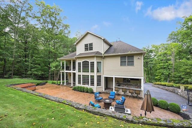 rear view of house featuring an outdoor living space, a yard, an outdoor bar, and a patio area