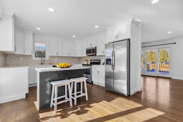 kitchen with stainless steel appliances, white cabinetry, and a kitchen island