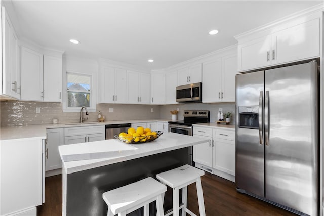 kitchen with sink, a center island, white cabinets, and appliances with stainless steel finishes