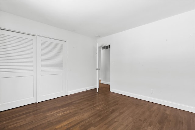 unfurnished bedroom featuring dark wood-type flooring and a closet