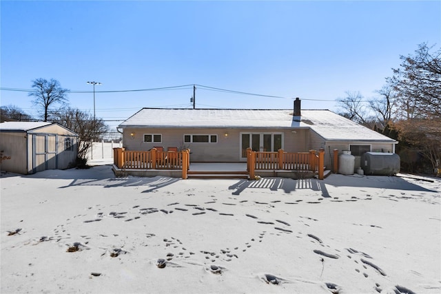 rear view of house featuring a wooden deck and a shed