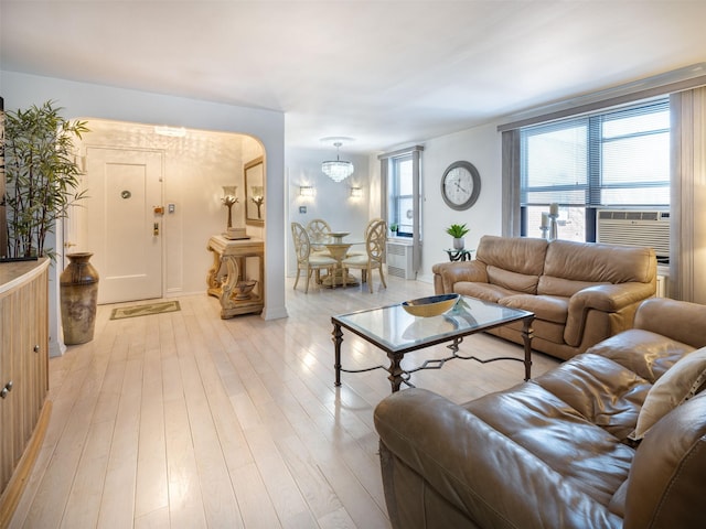 living room with a notable chandelier and light wood-type flooring