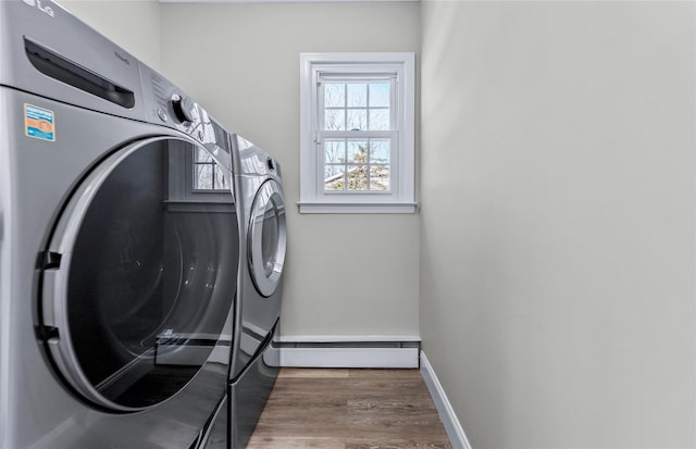 laundry area featuring a baseboard heating unit, dark wood-type flooring, and independent washer and dryer