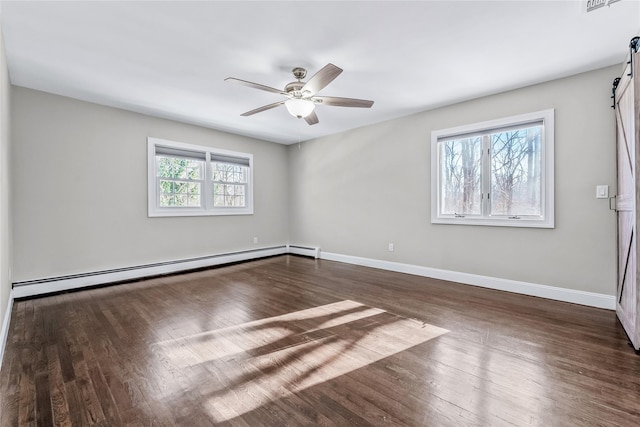 unfurnished room featuring ceiling fan, a barn door, a baseboard heating unit, and dark hardwood / wood-style floors