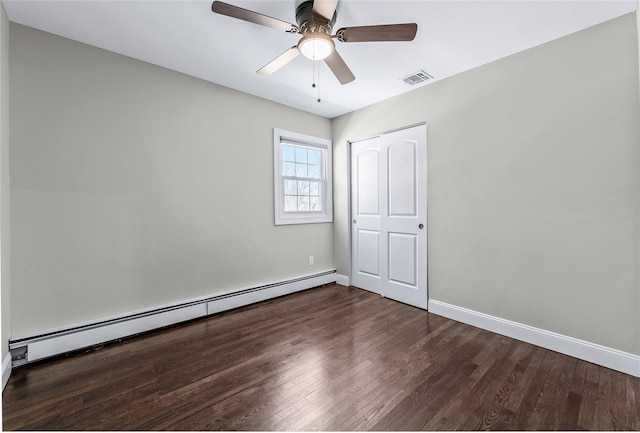 spare room with ceiling fan, a baseboard radiator, and dark hardwood / wood-style floors