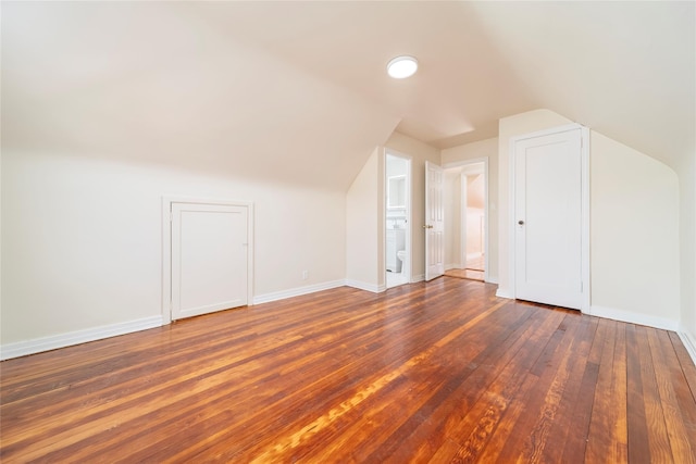 bonus room with lofted ceiling and dark hardwood / wood-style flooring