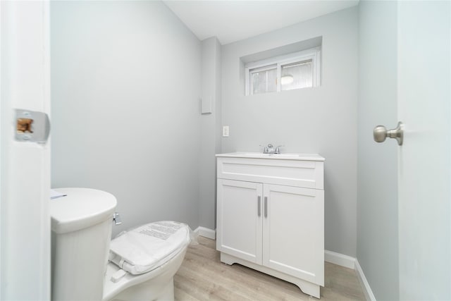 bathroom with vanity, hardwood / wood-style flooring, and toilet