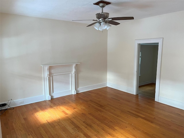 unfurnished living room featuring ceiling fan and dark hardwood / wood-style flooring