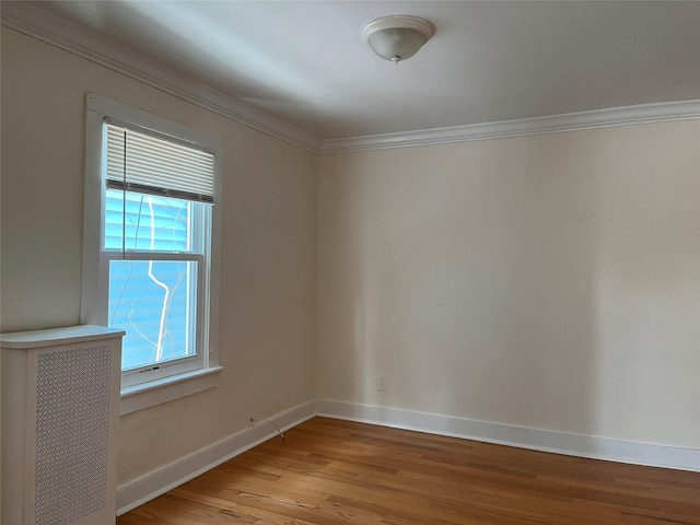 unfurnished room with radiator, crown molding, and light wood-type flooring