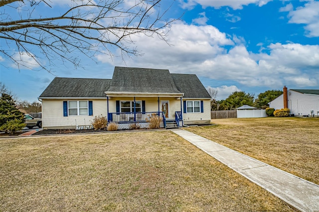 view of front of home featuring a front yard, covered porch, roof with shingles, and fence