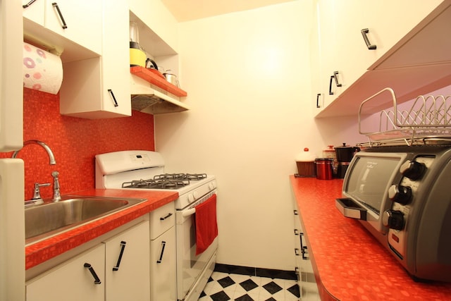 kitchen with white cabinets, sink, and white range with gas stovetop