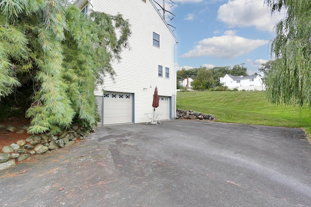 view of home's exterior featuring a garage and a lawn