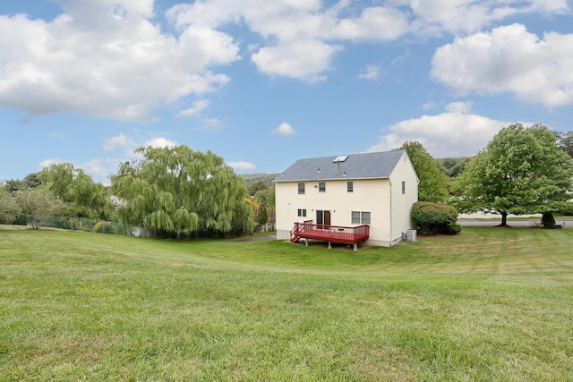 rear view of property featuring a yard and a deck