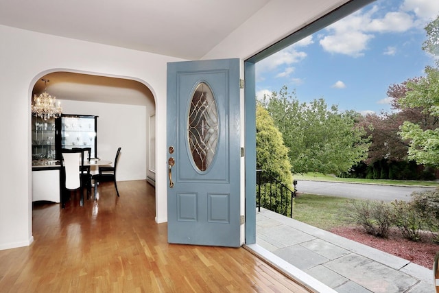 entryway featuring a healthy amount of sunlight, wood-type flooring, and a chandelier