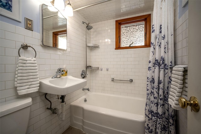 full bathroom with shower / tub combo with curtain, sink, tile walls, backsplash, and toilet