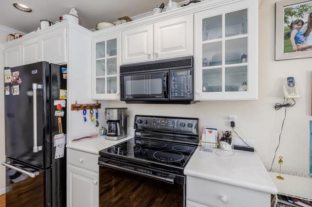 kitchen featuring black appliances, white cabinets, and dark hardwood / wood-style flooring